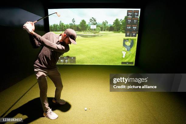 February 2022, Schleswig-Holstein, Glinde: Ex-professional soccer player Martin Harnik hits a ball in a golf simulator at the "Eisen Sieben" indoor...