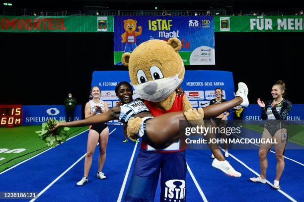 Britain's Daryll Neita celebrates with the mascot after winning the women's 60 m final race of the ISTAF indoor athletics meeting in Berlin on...