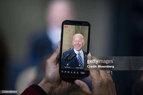 An attendee uses Facebook Live to record U.S. President Joe Biden speaking during an event at Ironworkers Local 5 in Upper Marlboro, Maryland U.S.,...