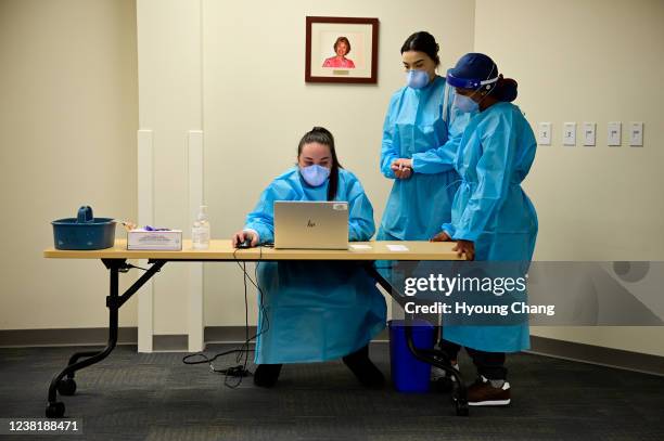 From left, Medical Assistants Chelsea Woodruff and Cierra Townsley and Licensed Practical Nurse Marisol Darge check PCR COVID-19 testing schedules at...