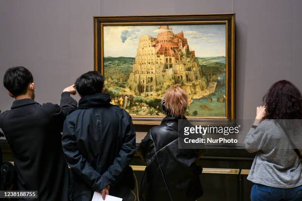 Visitors in protective masks against Covid-19 infection looking in painting of Pieter Bruegel the Elder in the Museum of Art History or...