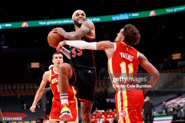 Gary Trent Jr. #33 of the Toronto Raptors puts up a shot over Trae Young of the Atlanta Hawks during the second half of their NBA game at Scotiabank...