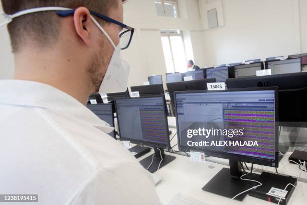 An employee in the laboratory of the company LifeBrain on a computer evaluates samples of the coronavirus PCR gargle test in Vienna on February 1,...