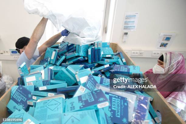 Employees of the company LifeBrain Logistik dispose of the empty packaging of samples of the coronavirus PCR gargle test in Vienna on February 1,...