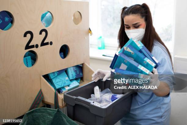 Employees of the company LifeBrain Logistik dispose of the empty packaging of samples of the coronavirus PCR gargle test in Vienna on February 1,...