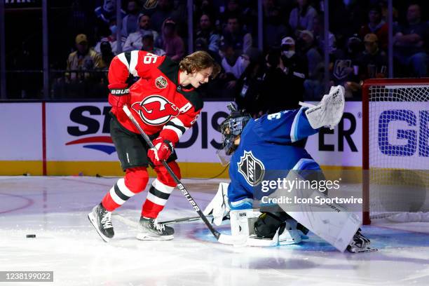 Manon Rheaume, the first woman to play goalie in an NHL game, makes a save against Jack Hughes New Jersey Devils forward during the NHL All-Star...