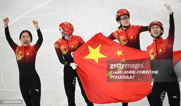 China's Wu Dajing , China's Fan Kexin and China's Qu Chunyu celebrate victory in the final A of the mixed team relay short track speed skating event...