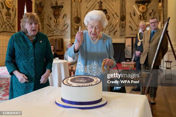 Queen Elizabeth II cuts a cake to celebrate the start of the Platinum Jubilee during a reception in the Ballroom of Sandringham House on February 5,...