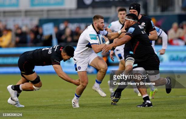 Will Butt of Bath is tackled by Theo McFarland of Saracens and Mako Vunipola of Saracens during the Gallagher Premiership Rugby match between...