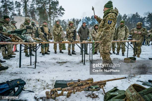 Army trainer of the 112th Territorial Defense Brigade of Kiev holds a deactivated grenade with a stick during the lessons of a military exercise for...
