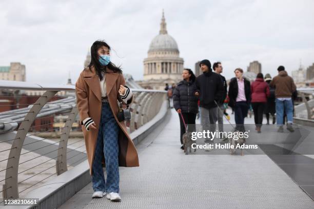 Pedestrians cross Millennium bridge on February 5, 2022 in London, England.
