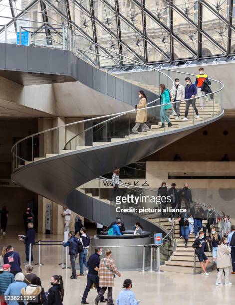 October 2021, France, Paris: Visitors walk through the glass pyramid in the Louvre. It represents the entrance for visitors and is a kind of center...
