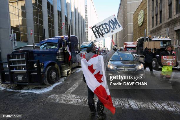 Person holds a sign reading "Freedom" as truckers and supporters continue to protest against mandates and restrictions related to Covid-19 vaccines...