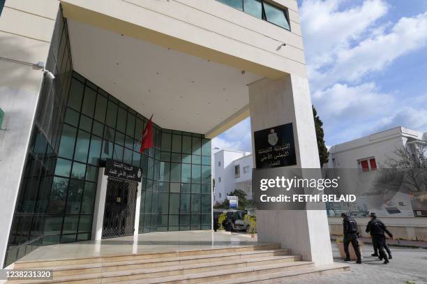 Members of the Tunisian security forces walk outside the closed entrance to the headquarters of Tunisia's Supreme Judicial Council in the capital...