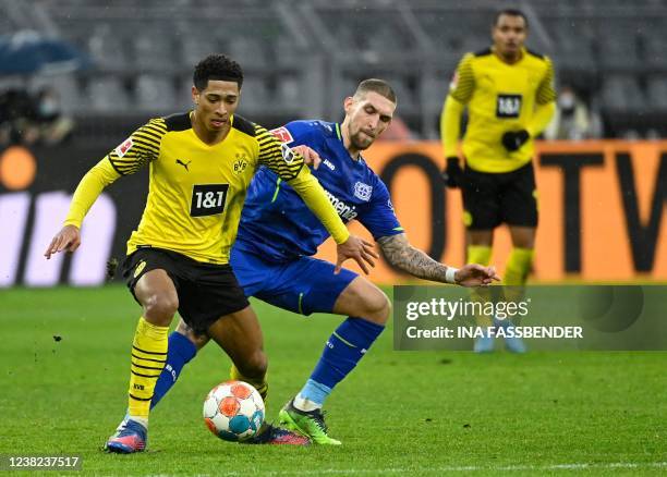 Dortmund's English midfielder Jude Bellingham and Leverkusen's German midfielder Robert Andrich vie for the ball during the German first division...