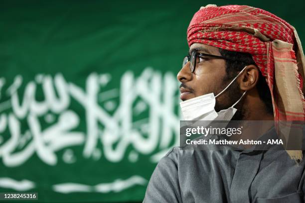 Fan of Al Hilal in front of the national flag of Saudi Arabia during the FIFA Club World Cup UAE 2021 2nd Round match between Al Hilal and Al Jazira...