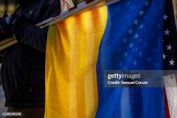 Pro-Ukrainian activist holds an American and Ukrainian flag together as activists gather for a prayer and demonstration against Russian aggression in...