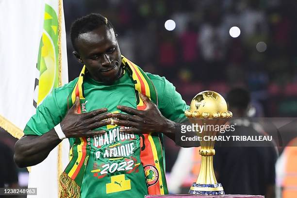 Senegal's forward Sadio Mane looks at the trophy prior to the ceremony after winning after the Africa Cup of Nations 2021 final football match...