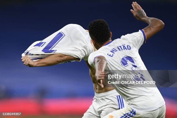 Real Madrid's Spanish midfielder Marco Asensio takes off his jersey as he celebrates after scoring a goal during the Spanish league football match...