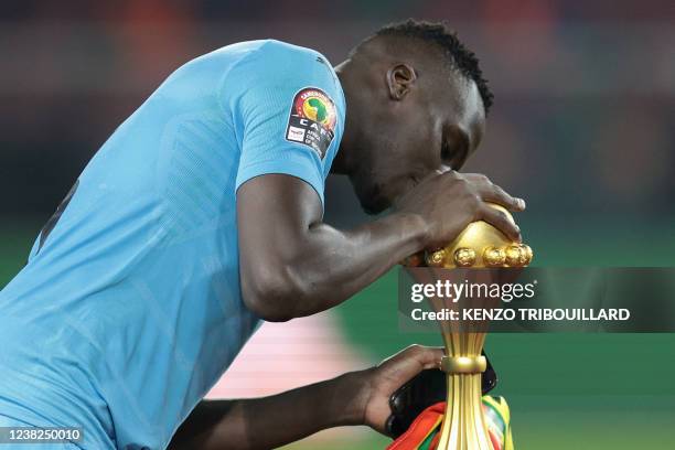 Senegal's goalkeeper Edouard Mendy kisses the trophy after winning the Africa Cup of Nations 2021 final football match between Senegal and Egypt at...