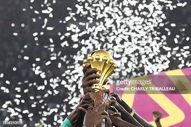 Senegal's players hold the trophy after winning the Africa Cup of Nations 2021 final football match between Senegal and Egypt at Stade d'Olembe in...