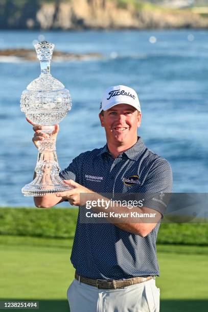 Tom Hoge smiles with the trophy following his two stroke victory during the final round of the AT&T Pebble Beach Pro-Am at Pebble Beach Golf Links on...