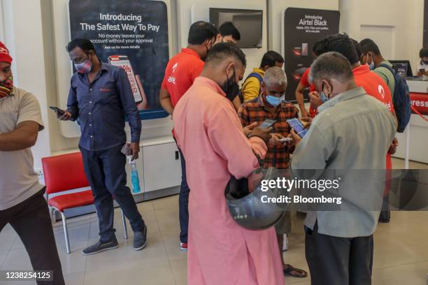 Customers use smartphones inside a Bharti Airtel Ltd. Store in Mumbai, India, on Saturday, Feb. 5, 2022. Bharti Airtel will release quarterly...