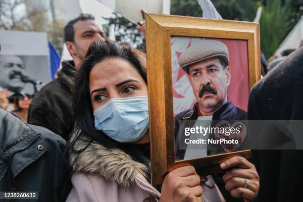 Female demonstrator holds a portrait of Chokri Belaid and his daughters during a demonstration held on the occasion of the 9th anniversary of the...