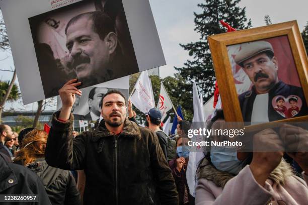 Demonstrators hold portraits of Chokri Belaid during a demonstration held on the occasion of the 9th anniversary of the assassination of the...