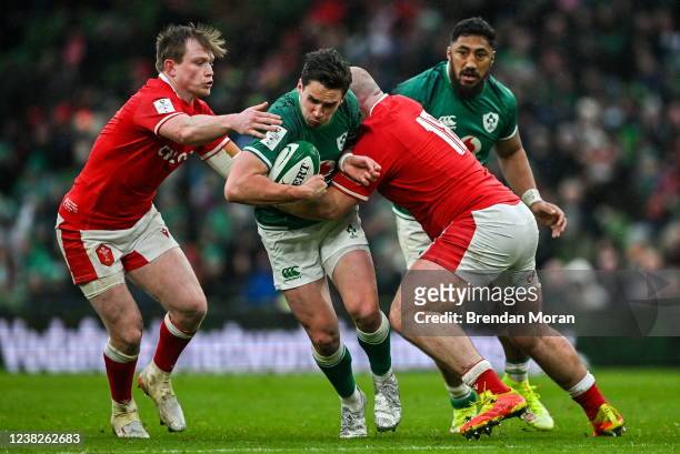 Dublin , Ireland - 5 February 2022; Joey Carbery of Ireland is tackled by Josh Adams and Dillon Lewis of Wales during the Guinness Six Nations Rugby...