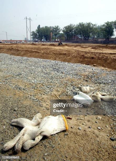 Gloves and a mask are seen strewn beside a road leading to the hospital erected in barely a week to house a rapidly increasing number of Chinese...