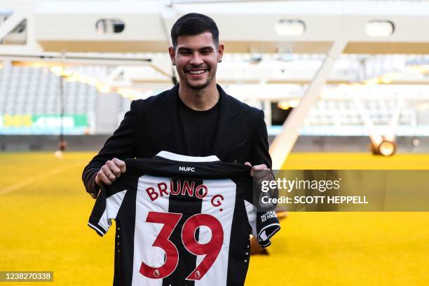 Newcastle United's Brazilian midfielder Bruno Guimaraes poses with his new jersey during a press conference in Newcastle, on February 7, 2022 as he...