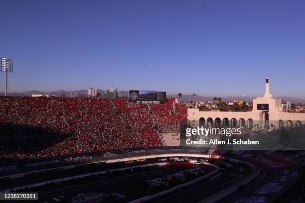 Los Angeles, CA With a view of downtown Los Angeles and snow-capped mountains in the background, NASCAR fans watch and cheer as racers circle the...