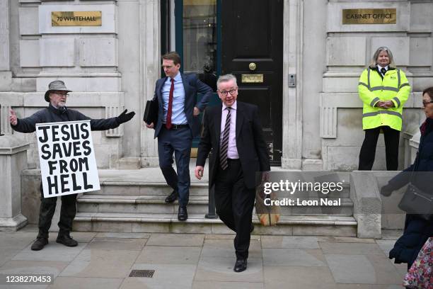 Protester shows a sign as Secretary of State for Levelling Up Michael Gove leaves the cabinet office in Whitehall, on February 7, 2022 in London,...