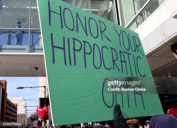 Boston, MA A protester holds a sign up reading honor your Hippocratic oath so that healthcare workers inside Brigham and Womens Hospital can see it...
