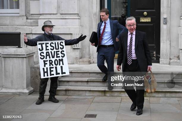 Protester shows a sign as Secretary of State for Levelling Up Michael Gove leaves the cabinet office in Whitehall, on February 7, 2022 in London,...