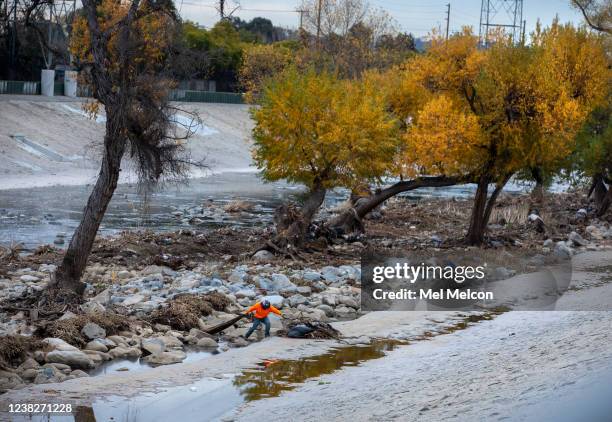 Landscaper with the City of Los Angeles picks up trash along the Los Angeles River in Los Angeles.