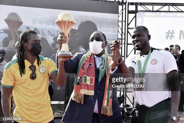 Senegal President Macky Sall stands with Sengal Captain Kalidou Koubaly holding the Africa Cup of Nations trophy upon Sengal arrval in Dakar on...