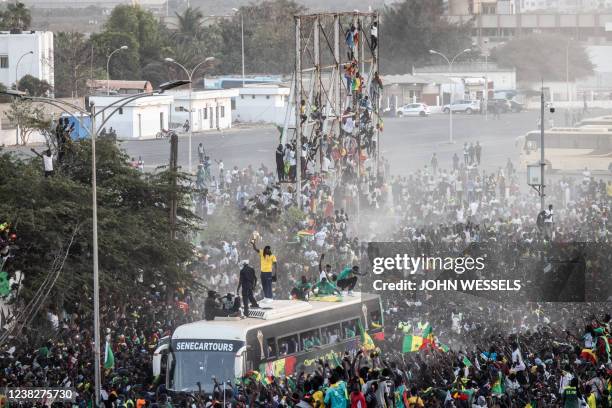 Supporters cheer as Aliou Cisse the Senegalese Football team's coach raises the trophy in Dakar on February 7 after winning, for the first time, the...