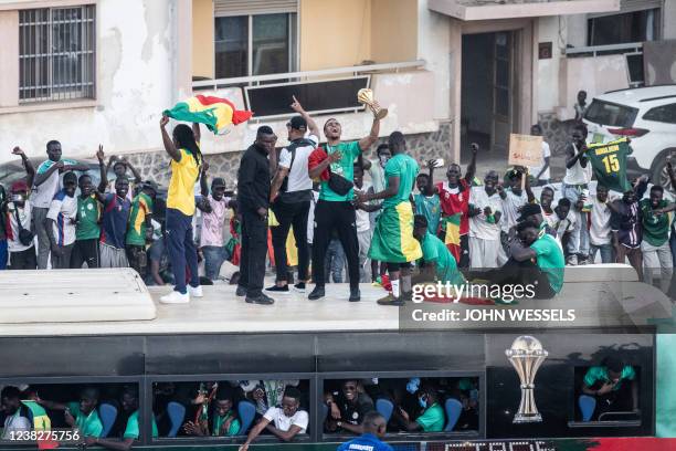 Supporters cheer as Abdou Diallo, Senegalese defender football player, raises the trophy in Dakar on February 7 after winning, for the first time,...