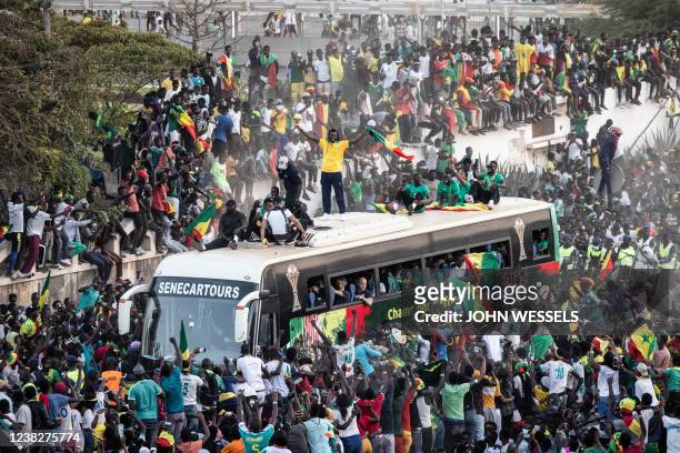 Supporters cheer as Aliou Cisse the Senegalese Football team's coach raises the trophy in Dakar on February 7 after winning, for the first time, the...