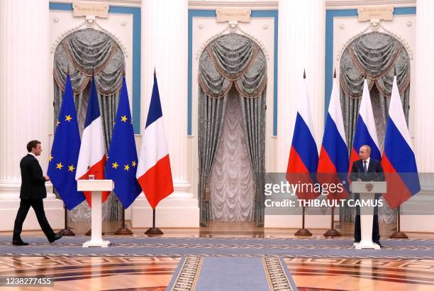 Russian President Vladimir Putin watches French President Emmanuel Macron arriving for a joint press conference after meeting in Moscow, on February...