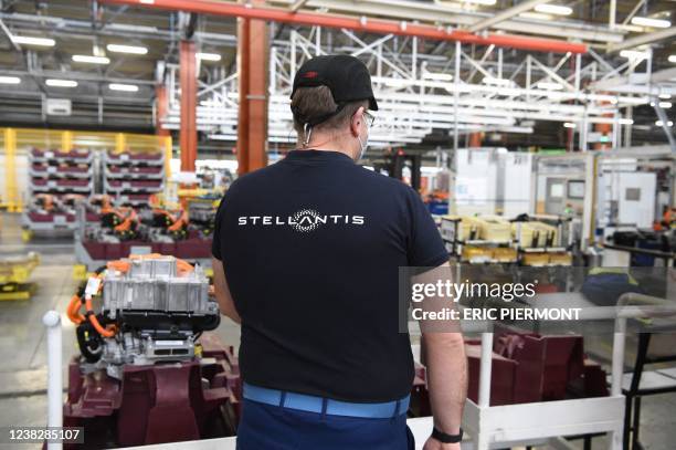 An employee works on an electric engine assembly line at automaker Stellantis plant in Tremery, eastern France, on January 27, 2022. - Stellantis, a...