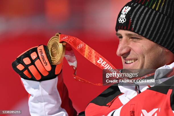 Gold medallist Austria's Matthias Mayer celebrates on the podium during the victory ceremony of the men's super-G final during the Beijing 2022...