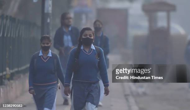 Students on their way to school on a cold and smoggy winter morning at NH-24, near Mayur Vihar , on February 7, 2022 in New Delhi, India.