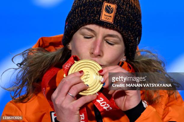 Gold medallist Netherland's Ireen Wust celebrates on the podium during the women's 1500m speed skating victory ceremony at the Beijing Medals Plaza...