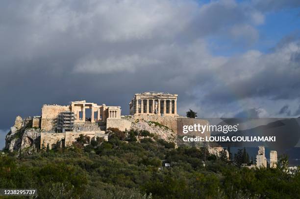 This photograph taken in Athens on February 8, 2022 shows a rainbow appearing over the Ancient Acropolis.