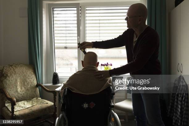 In this photo illustration an old man in a wheelchair is getting a haircut on February 05, 2022 in Heidelberg, Germany.