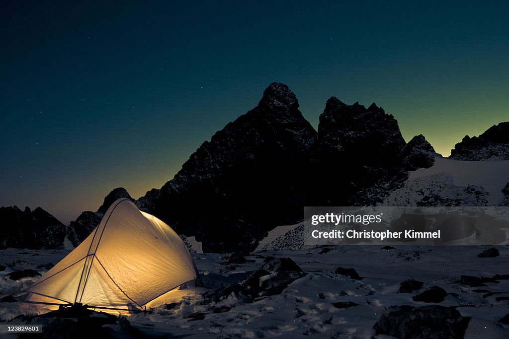 Tent with silhouette of mountain peak