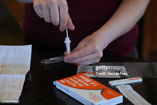Walmart worker processes a nasal swab in one of the new government-issued COVID-19 Antigen Rapid test kits she received as she self tests while at...
